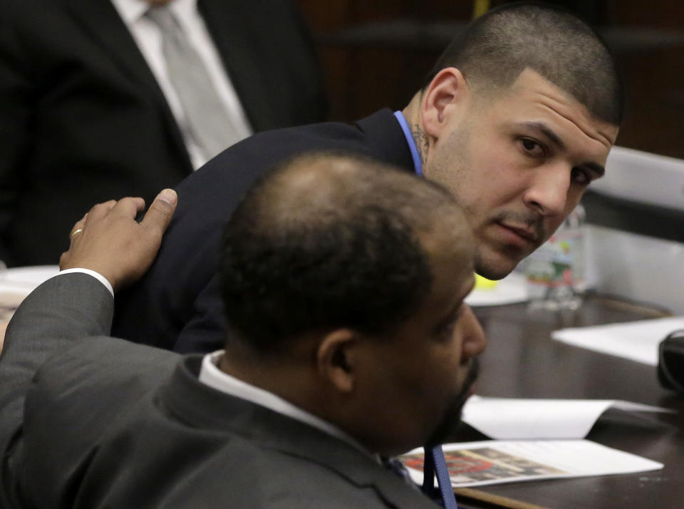 Former New England Patriots tight end Aaron Hernandez, top right, looks toward defense attorney Ronald Sullivan, front, during his double murder trial at Suffolk Superior Court, Thursday, April 6, 2017, in Boston. Hernandez is on trial for the July 2012 killings of Daniel de Abreu and Safiro Furtado who he encountered in a Boston nightclub. The former NFL player is already serving a life sentence in the 2013 killing of semi-professional football player Odin Lloyd. (AP Photo/Steven Senne, Pool)