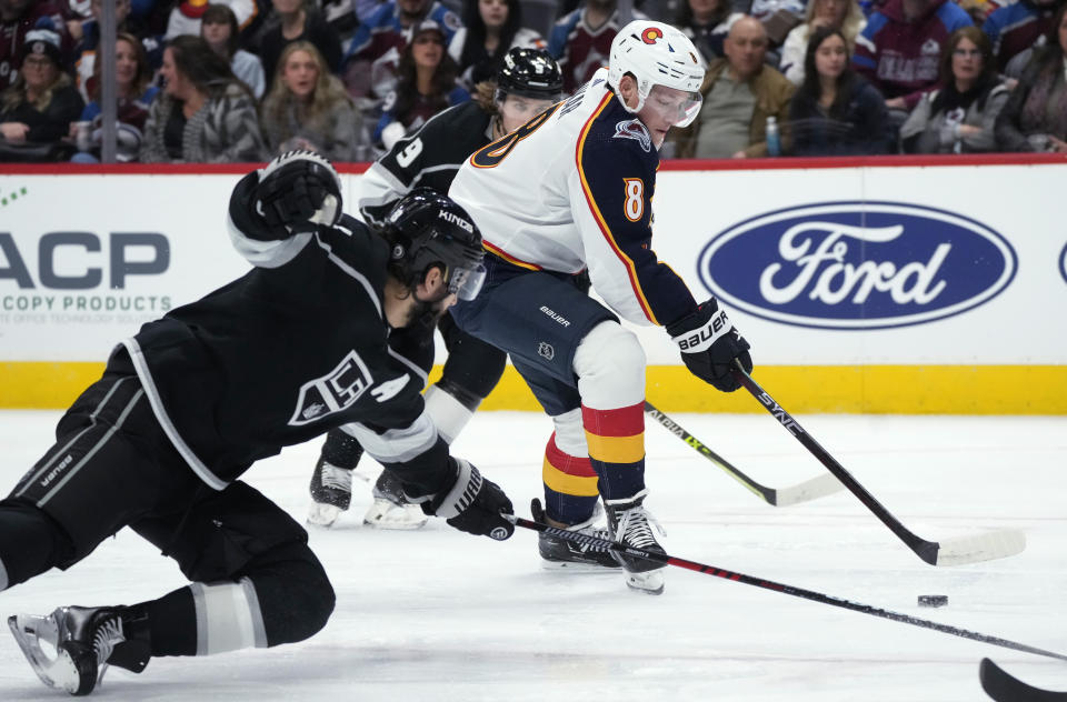 Colorado Avalanche defenseman Cale Makar, center, drives between Los Angeles Kings defenseman Drew Doughty, front, and right wing Adrian Kempe during the first period of an NHL hockey game Thursday, Dec. 29, 2022, in Denver. (AP Photo/David Zalubowski)