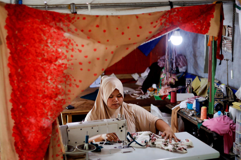 Asnia Muloc Sandiman, 25, works with a sewing machine provided by the government in her family's tent at an evacuation camp for families displaced by the Marawi siege, in Marawi City, Lanao del Sur province, Philippines. (Photo: Eloisa Lopez/Reuters)