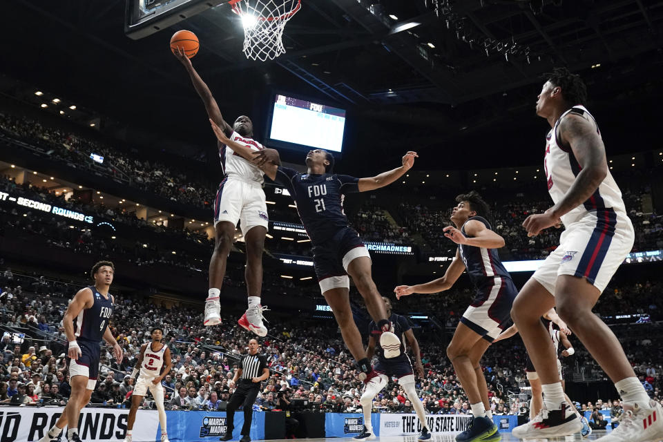 Florida Atlantic guard Johnell Davis (1) drives on Fairleigh Dickinson forward Cameron Tweedy (21) in the first half of a second-round men's college basketball game in the NCAA Tournament Sunday, March 19, 2023, in Columbus, Ohio. (AP Photo/Paul Sancya)