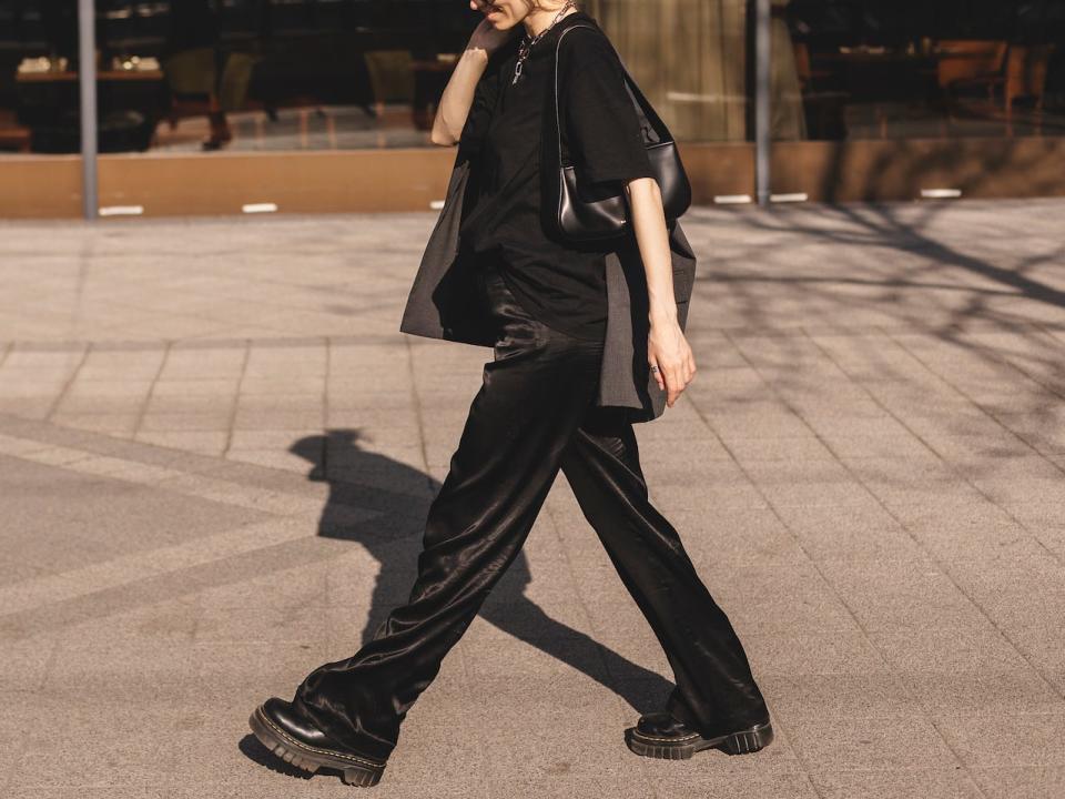 woman walking down the street wearing a black monochrome outfit