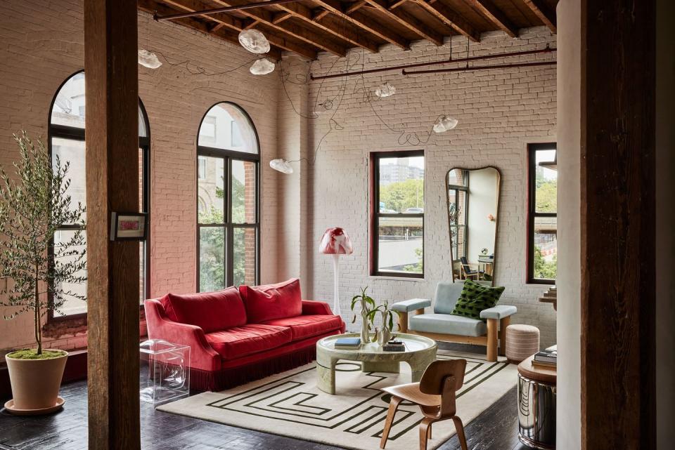 a living room with a red couch and a table