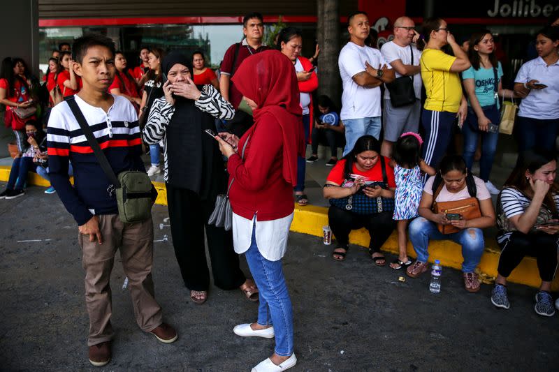 Shoppers and vendors stand outside Virra Mall where gunshots were fired in San Juan City, Metro Manila