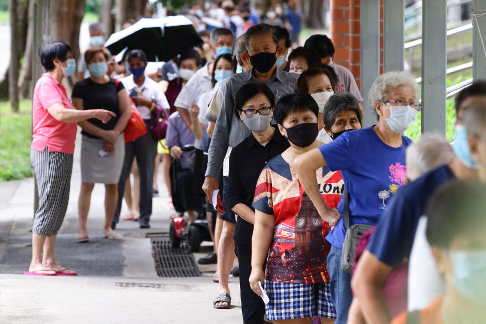 Voters wearing protective masks queue to enter a polling station during the general election on July 10, 2020 in Singapore. (Photo by Suhaimi Abdullah/Getty Images)