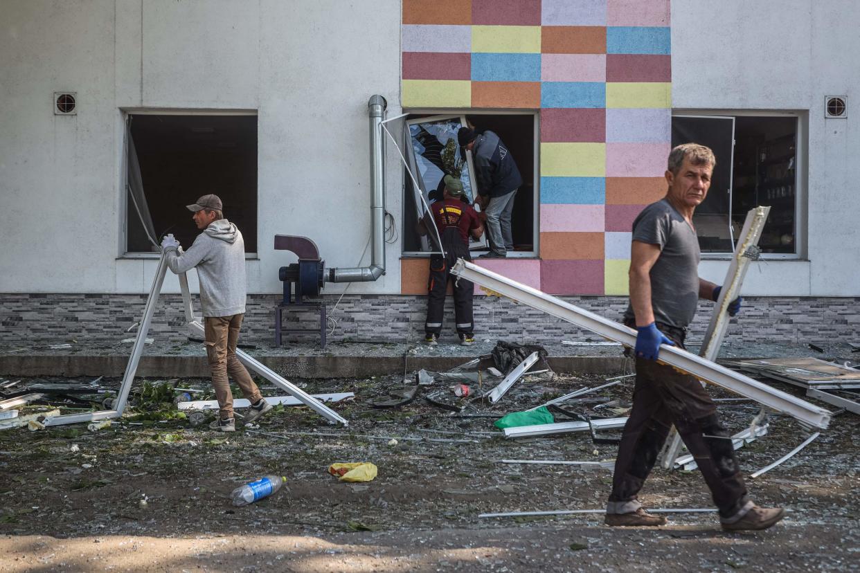 Local residents clear debris after a Russian missile strike in Odesa (AFP via Getty Images)