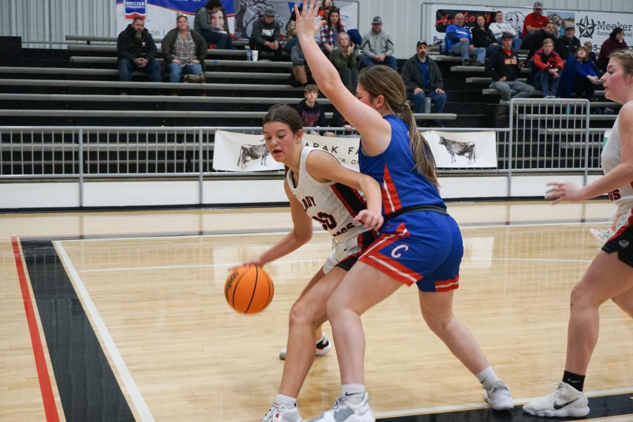 Meeker sophomore Aviary Helms (00) drives the baseline looking for a shot against a Chandler defender Tuesday night in Meeker.