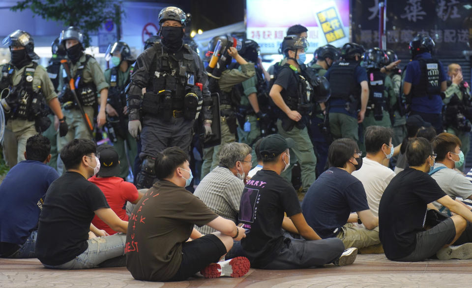In this July 1, 2020, file photo, police officers detain protesters against the new security law during a march marking the anniversary of the Hong Kong handover from Britain to China in Hong Kong. A national security law enacted in 2020 and COVID-19 restrictions have stifled major protests in Hong Kong including an annual march on July 1. (AP Photo/Vincent Yu, File)