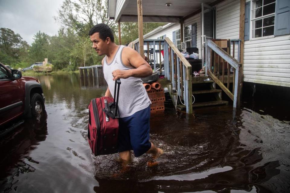 Chavez Gallegos, 24, helps his family move out of a flooded home on Will Baker Road in Kinston Sunday, Sept. 16, 2018, following the aftermath of Hurricane Florence.