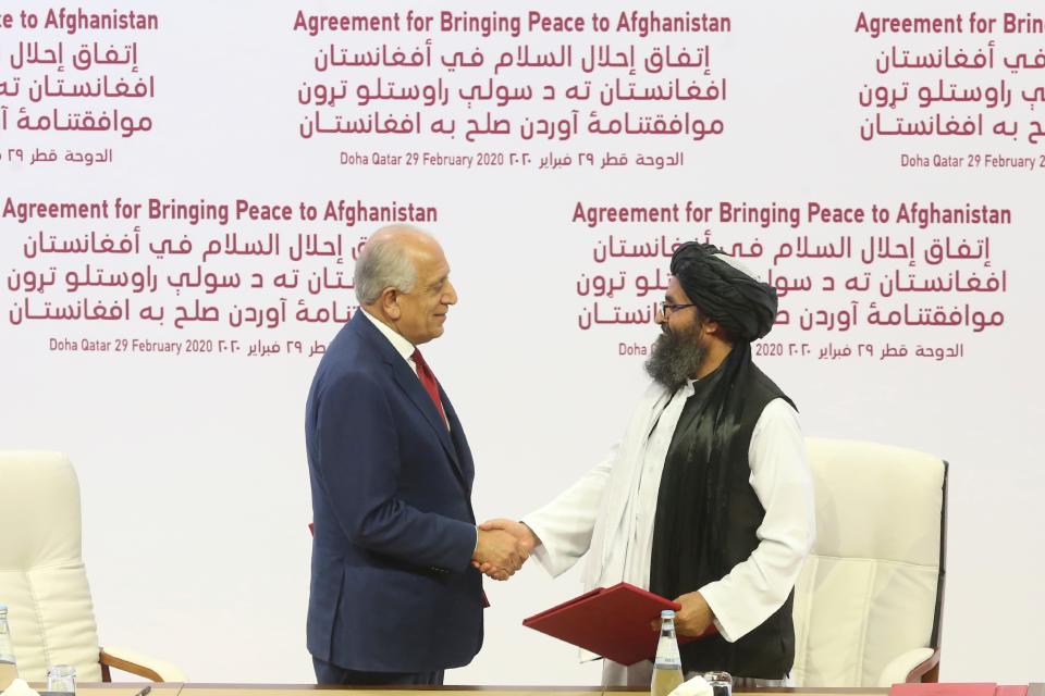 In this Feb. 29, 2020, U.S. peace envoy Zalmay Khalilzad, left, and Mullah Abdul Ghani Baradar, the Taliban group's top political leader shack hands after signing a peace agreement between Taliban and U.S. officials in Doha, Qatar.