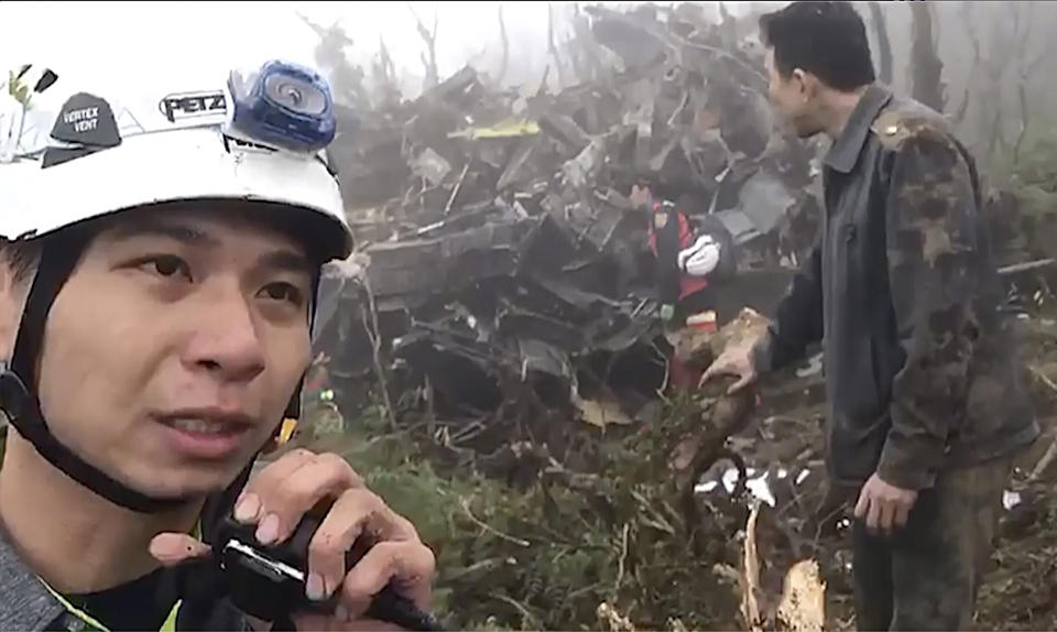In this image made from video, emergency teams work at the crash site of a military helicopter in the mountains of Yilan, north eastern Taiwan, Thursday, Jan. 2, 2020. The defense ministry has confirmed Taiwan's top military officer Gen. Shen Yi-ming and others were killed in a crash of an air force helicopter. (Yilan Fire Bureau via AP)