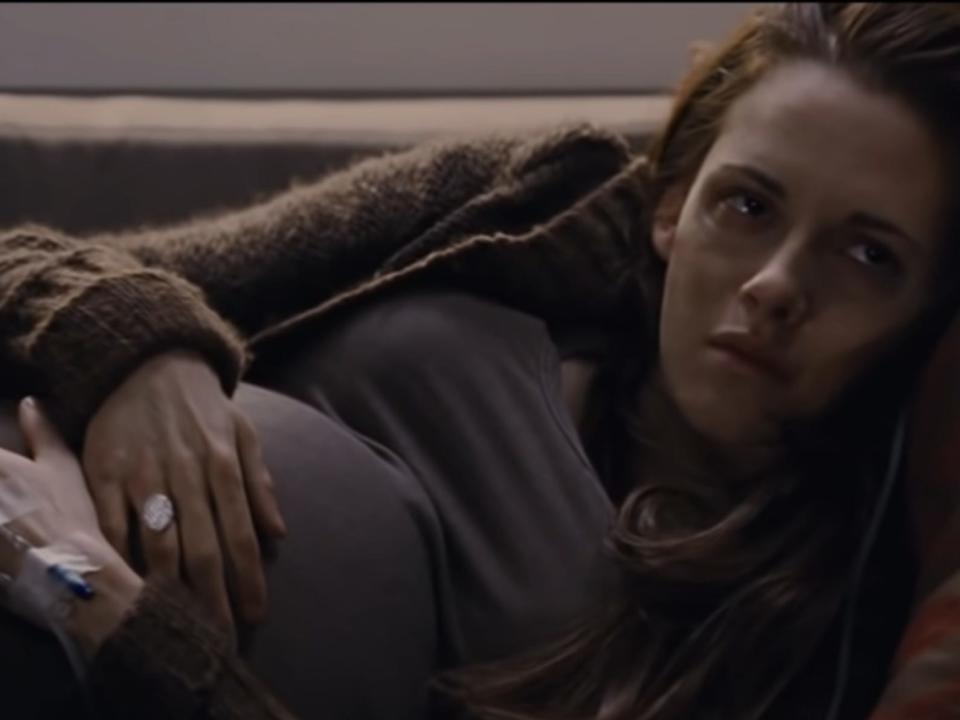 pregnant bella laying on the couch with ivs in her hands in twilight breaking dawn