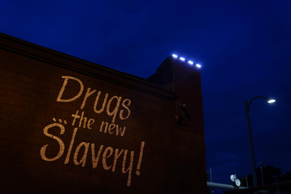 A sign painted on the side of a corner store reads, "Drugs... the new Slavery!" in St. Louis on Friday, May 21, 2021. As the COVID-19 pandemic intensified America’s opioid addiction crisis in nearly every corner of the country, many Black neighborhoods like this one suffered most acutely. (AP Photo/Brynn Anderson)
