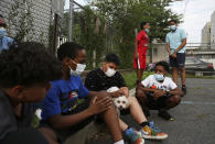 St. Francis Xavier students sit together for the first time in five months after their school was closed due to the coronavirus pandemic, Thursday, Aug. 6, 2020, in Newark. The students and their concerned families gathered at the school to discuss its permanent closure, announced by the Archdiocese of Newark the previous week. (AP Photo/Jessie Wardarski)
