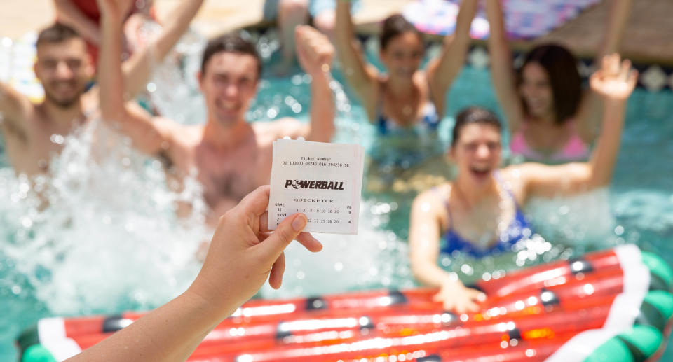 A Powerball ticket in front of people in the pool.