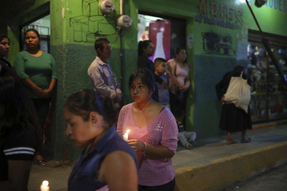 Mourners carry candles as they greet the hearse bringing the body of Maricela Vallejo, the slain 27-year-old mayor of Mixtla de Altamirano, to her aunt's house in Zongolica, Veracruz state, Mexico, Thursday, April 25, 2019. Vallejo, her husband, and a driver were assassinated Thursday by multiple gunmen as they drove along a highway. (AP Photo/Felix Marquez)