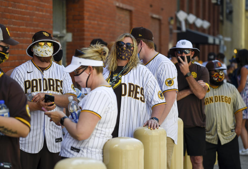 Baseball fans wait in line before the gates opened up before a baseball game between the Arizona Diamondbacks and the San Diego Padres Thursday, April 1, 2021, on opening day in San Diego. The U.S. moved closer Thursday toward vaccinating 100 million Americans in a race against an uptick in COVID-19 cases that is fueling fears of another nationwide surge just as the major league baseball season starts and thousands of fans return to stadiums. (AP Photo/Denis Poroy)