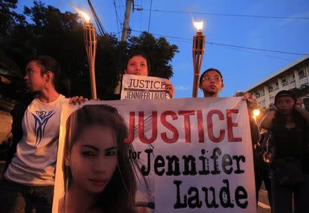 Demonstrators display a banner while holding torches, seeking justice for murdered Filipino transgender Jeffrey Laude, who also goes by the name Jennifer, during a protest along a main street of Manila October 24, 2014. REUTERS/Romeo Ranoco