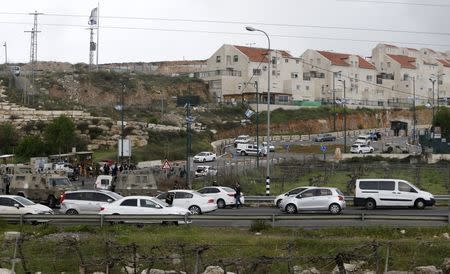 Israeli security forces gather at the scene of what the Israeli military said were back-to-back gun and car-ramming attacks by Palestinians, near the Jewish settlement of Kiryat Arba near the West Bank city of Hebron March 14, 2016. REUTERS/Mussa Qawasma