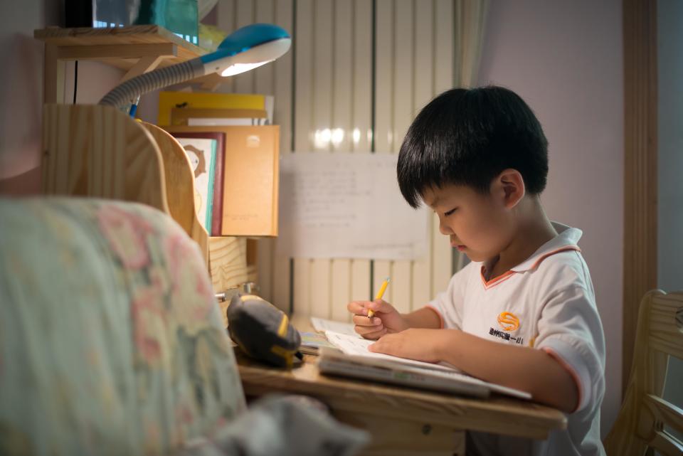 Wei Hanqi, 9, completes his homework at his home in Beijing on June 19, 2013. 