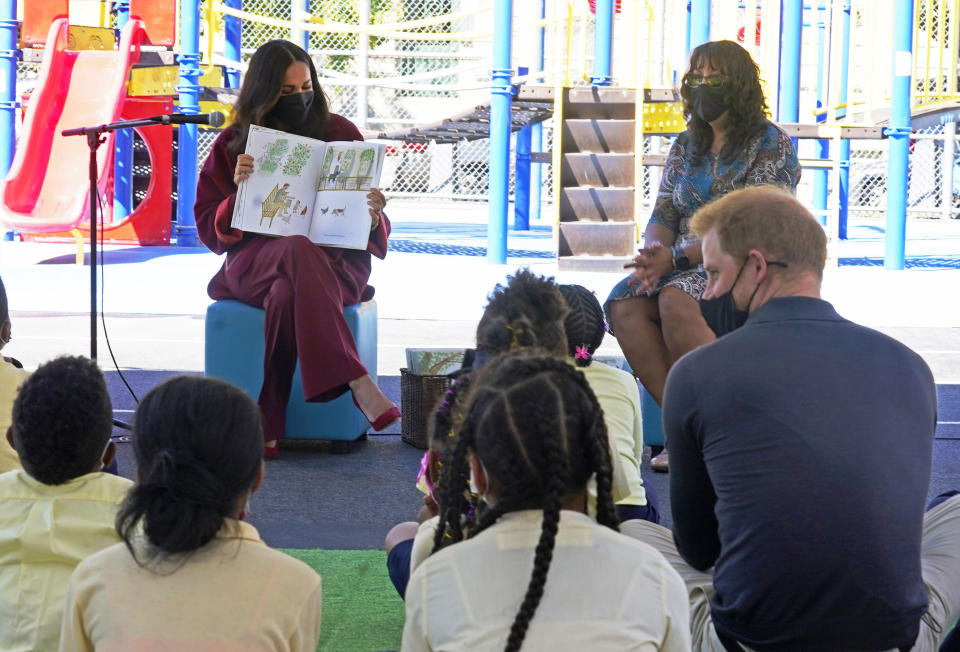 Meghan, the Duchess of Sussex, reads from her book "The Bench," as Prince Harry, the Duke of Sussex, foreground right, and second grade students listen, during their visit to P.S. 123, the Mahalia Jackson School, in New York's Harlem neighborhood, Friday, Sept. 24, 2021. Seated background right is Principal Melitina Hernandez. (AP Photo/Richard Drew)