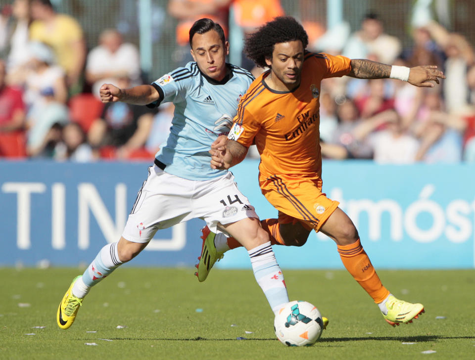 Real Madrid's Marcelo from Brazil, right, vies for the ball with Celta's Fabian Orellana from Chile during a Spanish La Liga soccer match at the Balaidos stadium in Vigo, Spain, Sunday, May 11, 2014. (AP Photo/Lalo R. Villar)