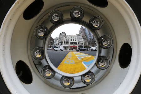 The finish line of the Boston Marathon is reflected in the wheel of a truck on the second day of jury selection in the trial of accused Boston Marathon bomber Dzhokhar Tsarnaev in Boston, Massachusetts January 6, 2015. REUTERS/Brian Snyder