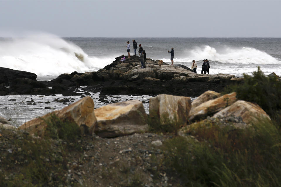 People watch waves from Lee, Saturday, Sept. 16, 2023, in Rye, N.H. The storm is expected to make landfall Saturday in Canada at near hurricane strength and then move farther into the region. (AP Photo/Caleb Jones)