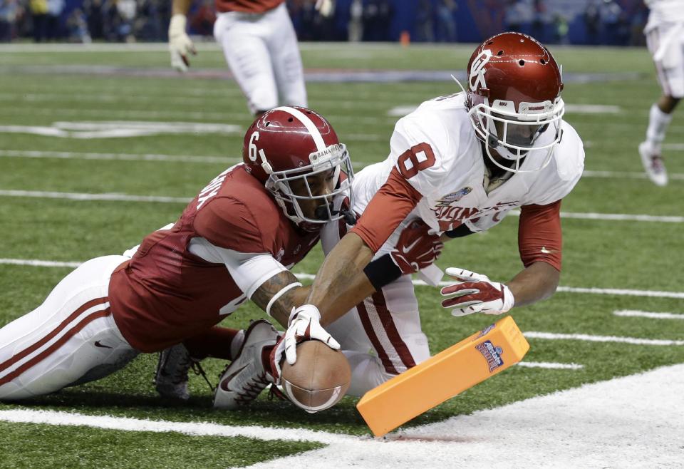 Oklahoma wide receiver Jalen Saunders (8) scores a touchdown as Alabama defensive back Ha Ha Clinton-Dix (6) tries to tackle during the first half of the Sugar Bowl NCAA college football game in New Orleans, Thursday, Jan. 2, 2014. (AP Photo/Rusty Costanza)