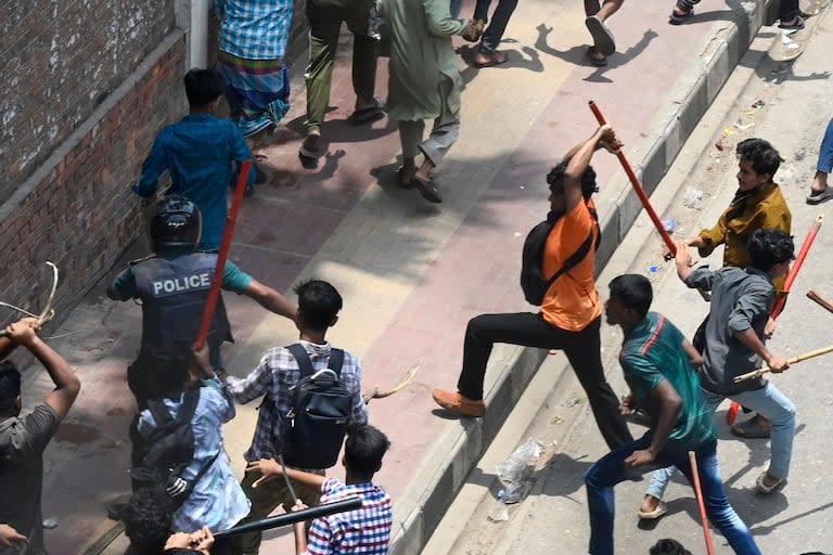 Manifestantes golpean a un policía en Daca