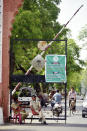 Policemen sit at the entrance of Aligarh Muslim University (AMU) with a banner announcing its closure because of the coronavirus pandemic in Aligarh, India, Saturday, June 12, 2021. Within just one month, the official Facebook page of Aligarh Muslim University, one of the topmost in India, published about two dozen obituaries of its teachers, all lost to the pandemic. Across the country, the deaths of educators during the devastating surge in April and May have left students and staff members grief-stricken and close-knit university communities shaken. (AP Photo/Manoj Aligadi)