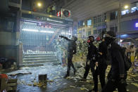 Protesters throw brick to a police station in Hong Kong on Friday, Sept. 6, 2019. The ratings agency Fitch on Friday cut Hong Kong's credit rating and warned that conflict with anti-government protesters was hurting the image of its business climate. (AP Photo/Kin Cheung)