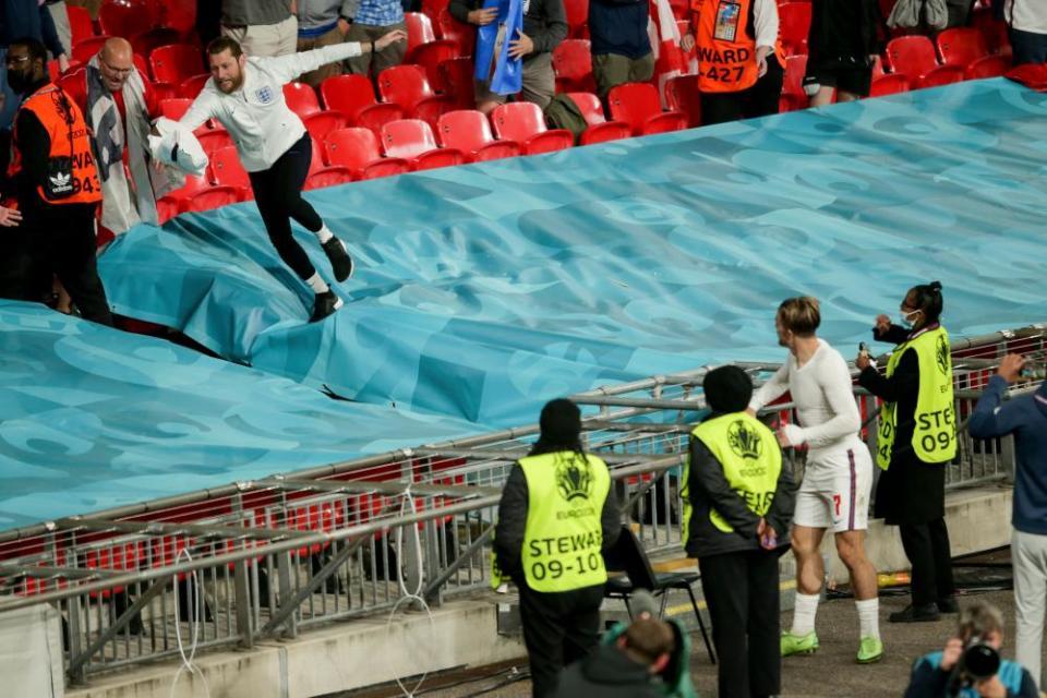 Jack Grealish throws his shirt to an England fan in the crowd after the match.