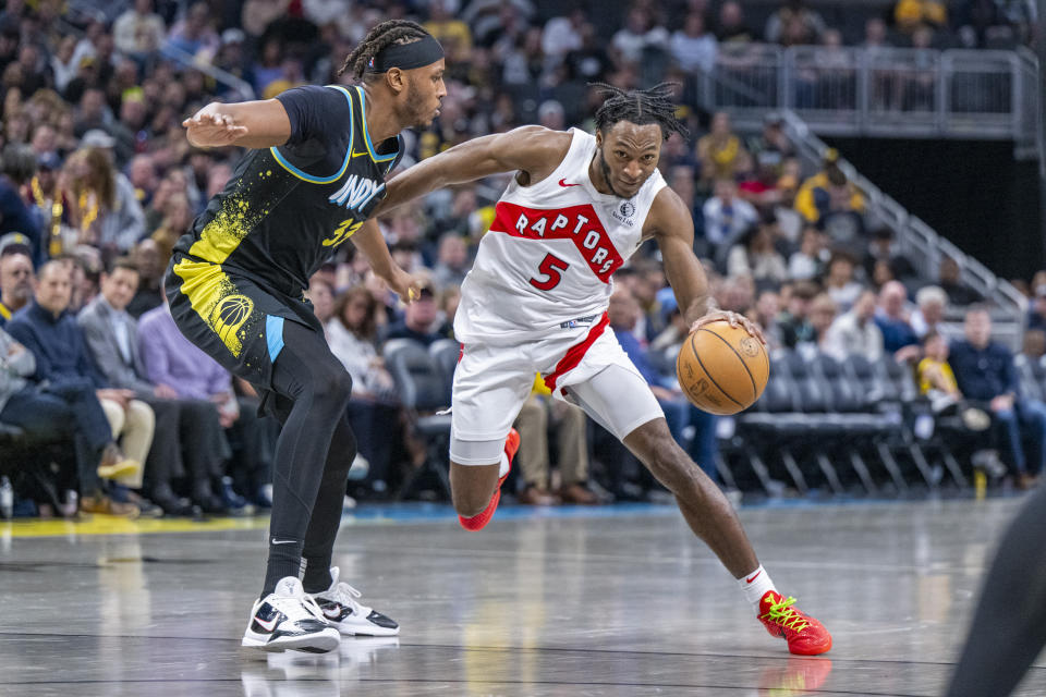 Toronto Raptors guard Immanuel Quickley (5) moves around the defense of Indiana Pacers center Myles Turner (33) during the second half of an NBA basketball game in Indianapolis, Monday, Feb. 26, 2024. (AP Photo/Doug McSchooler)