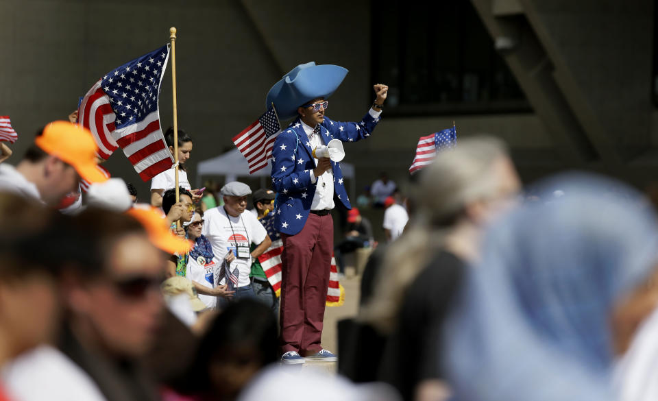 Bhavik Patel raises his fist during a protest rally in downtown Dallas, Sunday, April 9, 2017. Thousands of people are marching and rallying in downtown Dallas to call for an overhaul of the nation's immigration system and end to what organizers say is an aggressive deportation policy. (AP Photo/LM Otero)
