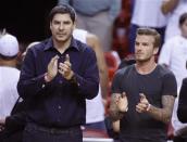 Former soccer player David Beckham (R) and Marcelo Claure, CEO of Brightstar applaud before Game 5 of the NBA Eastern Conference final basketball playoff between the Indiana Pacers and the Miami Heat in Miami, Florida in this May 30, 2013, file photo. REUTERS/Joe Skipper/Files