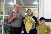 Iranian voters display their ink-stained fingers after casting their ballot at a polling station in Robat Karim, on April 29, 2016