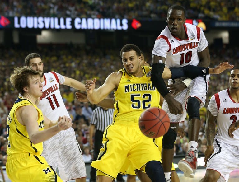 Louisville Cardinals' Luke Hancock (2nd L) and Gorgui Dieng (2nd R) fight for the ball during their game against the Michigan Wolverines on April 8, 2013. Hancock scored 22 points to lead the Cardinals over the Wolverines 82-76 in the National Collegiate Athletic Association men's basketball final