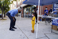 Former President Barack Obama speaks speaks to a child outside of a Democratic Voter Activation Center as he campaigns for Democratic presidential candidate former Vice President Joe Biden, Wednesday, Oct. 21, 2020. (AP Photo/ Matt Slocum)