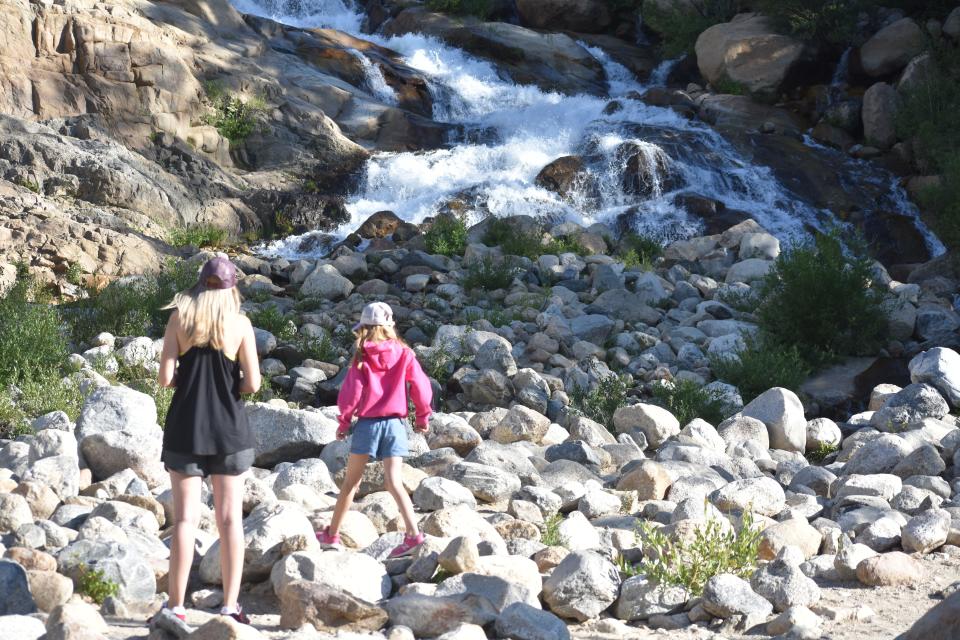 Rocky Mountain National Park visitors stand next to the Roaring River in an alluvial fan on Wednesday. The fan was created when the Lawn Lake dam breached causing a flood on July 15, 1982.
