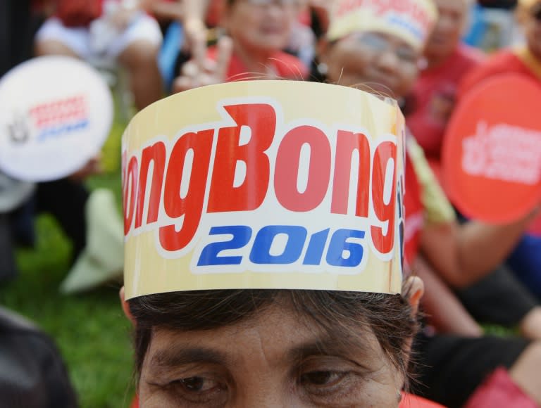 A supporter of Ferdinand Marcos Jr. (C), the son of the late Philipine dictator Ferdinand Marcos, looks on as he announces his vice-presidential bid at a political rally in Manila on October 10, 2015