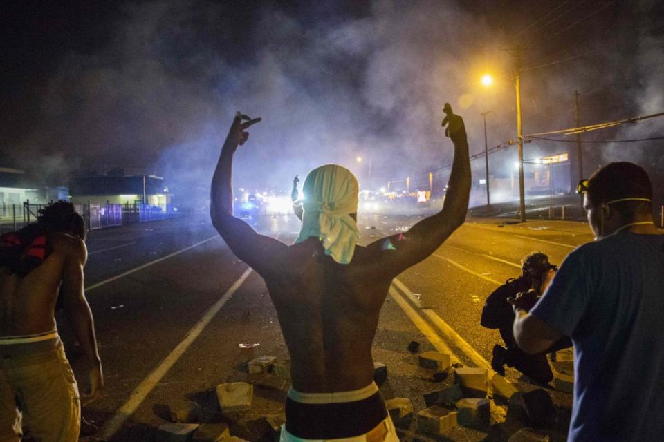 <p>Demonstrators face off with police after tear gas was fired at protesters reacting to the shooting of Michael Brown in Ferguson, Missouri August 17, 2014. (Lucas Jackson/Reuters) </p>