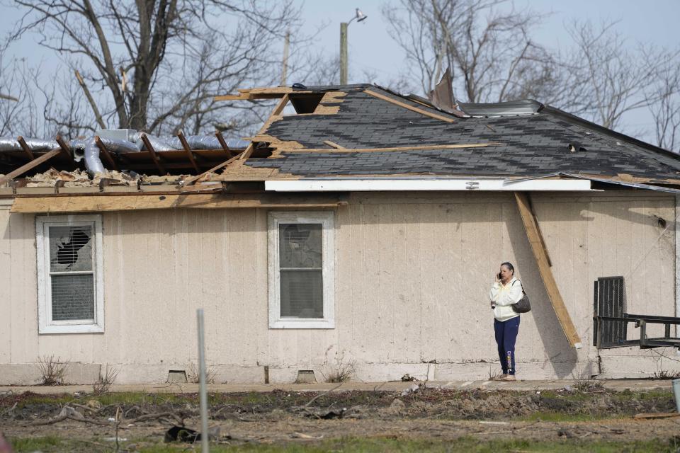 Patricia Johnson uses her cellphone as she walks next to her home that was destroyed by Friday night's tornado in Silver City, Miss., Tuesday, March 28, 2023. Johnson is married to a county supervisor, and like many of the small community's residents, lost much of their personal possessions and vehicles to the storm. (AP Photo/Rogelio V. Solis)