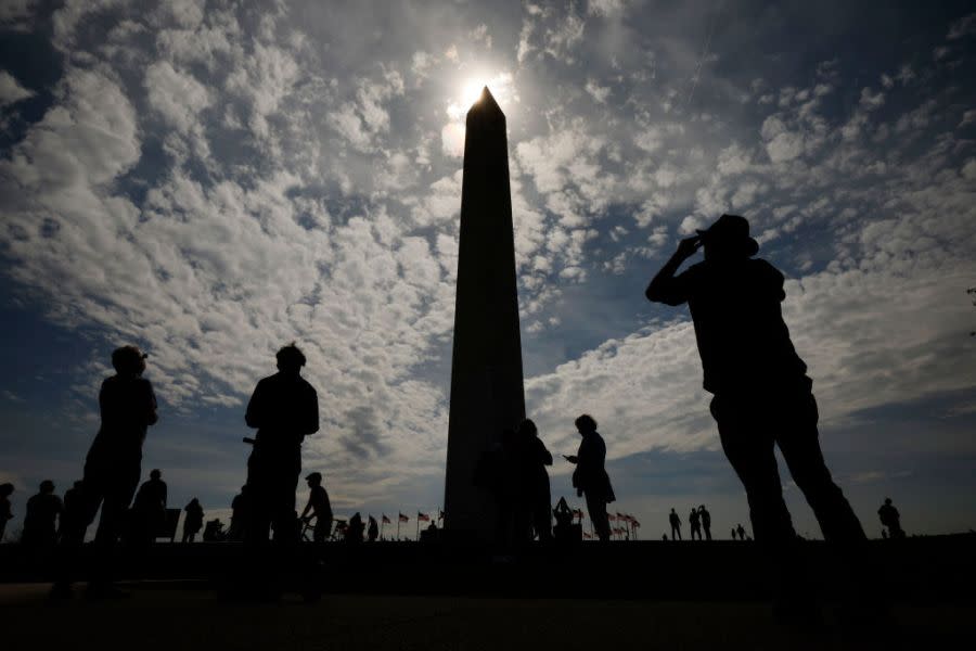 Photographers capture the solar eclipse near the base of the Washington Monument on the National Mall on April 08, 2024 in Washington, DC. People have traveled to areas across North America that are in the “path of totality” in order to experience the eclipse today. The next total solar eclipse that can be seen from a large part of North America won’t happen until 2044. (Photo by Chip Somodevilla/Getty Images)