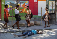 Pedestrians walk past a body of a prison inmate lying on a street near the Croix-des-Bouquets Civil Prison after an attempted breakout, in Port-au-Prince, Haiti, Thursday, Feb. 25, 2021. At least seven people were killed and one injured on Thursday after eyewitnesses told The Associated Press that several inmates tried to escape from a prison in Haiti’s capital. (AP Photo/Dieu Nalio Chery).