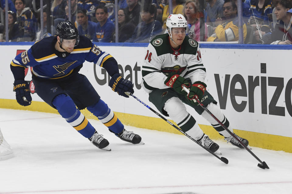 Minnesota Wild's Joel Eriksson Ek (14) works the puck against St. Louis Blues' Colton Parayko (55) during the first period in Game 4 of an NHL hockey Stanley Cup first-round playoff series on Sunday, May 8, 2022, in St. Louis. (AP Photo/Michael Thomas)