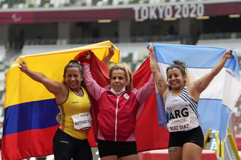 From left, Silver medalist Mayerli Buitrago Ariza of Columbia, Gold medalist Tunisia's Raoua Tlili of Tunisia and Bronze medalist Antonella Ruiz Diaz of Argentina celebrate after wining the women's shot put at the Tokyo 2020 Paralympics Games in Tokyo, Japan Friday, Aug. 27, 2021. (AP Photo/Eugene Hoshiko)