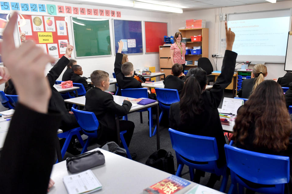 STALYBRIDGE, ENGLAND - SEPTEMBER 09: Pupils raise their hands in a lesson as they return to school at Copley Academy on September 09, 2021 in Stalybridge, England. Senior school pupils, returning to school across the UK during the second year of the worldwide Coronavirus pandemic, are taking part in a mass program of lateral flow tests designed to minimise the risk of spreading Covid-19. (Photo by Anthony Devlin/Getty Images)