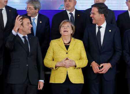 French President Emmanuel Macron, German Chancellor Angela Merkel and Dutch Prime Minister Mark Rutte take part in a group photo on the launching of the Permanent Structured Cooperation, or PESCO, a pact between 25 EU governments to fund, develop and deploy armed forces together, during a EU summit in Brussels, Belgium, December 14, 2017. REUTERS/Yves Herman