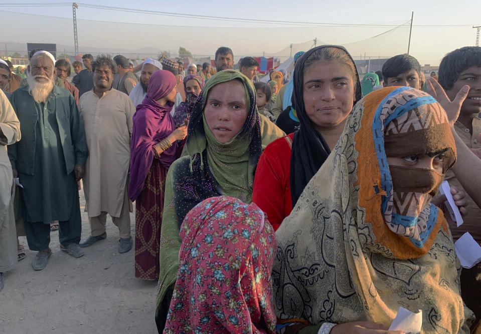 Afghan families gather to receive food stuff distributing by an Islamabad-based Christian organization on the outskirts of Chaman, a border town in the Pakistan's southwestern Baluchistan province, Tuesday, Aug. 31, 2021. Dozens of Afghan families have crossed into Pakistan through the southwestern Chaman border a day after the U.S. wrapped up its 20-year military presence in the Taliban-controlled country. (AP Photo)