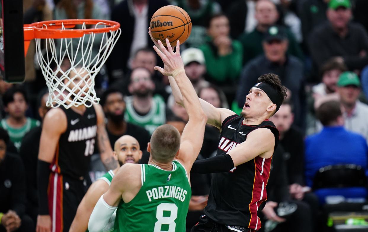 Miami Heat guard Tyler Herro (14) drives to the basket against Boston Celtics center Kristaps Porzingis (8) in the second half of Game 2.